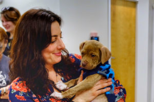 Woman Holding Brown Puppy At The Oak Heart Longview Grand Opening